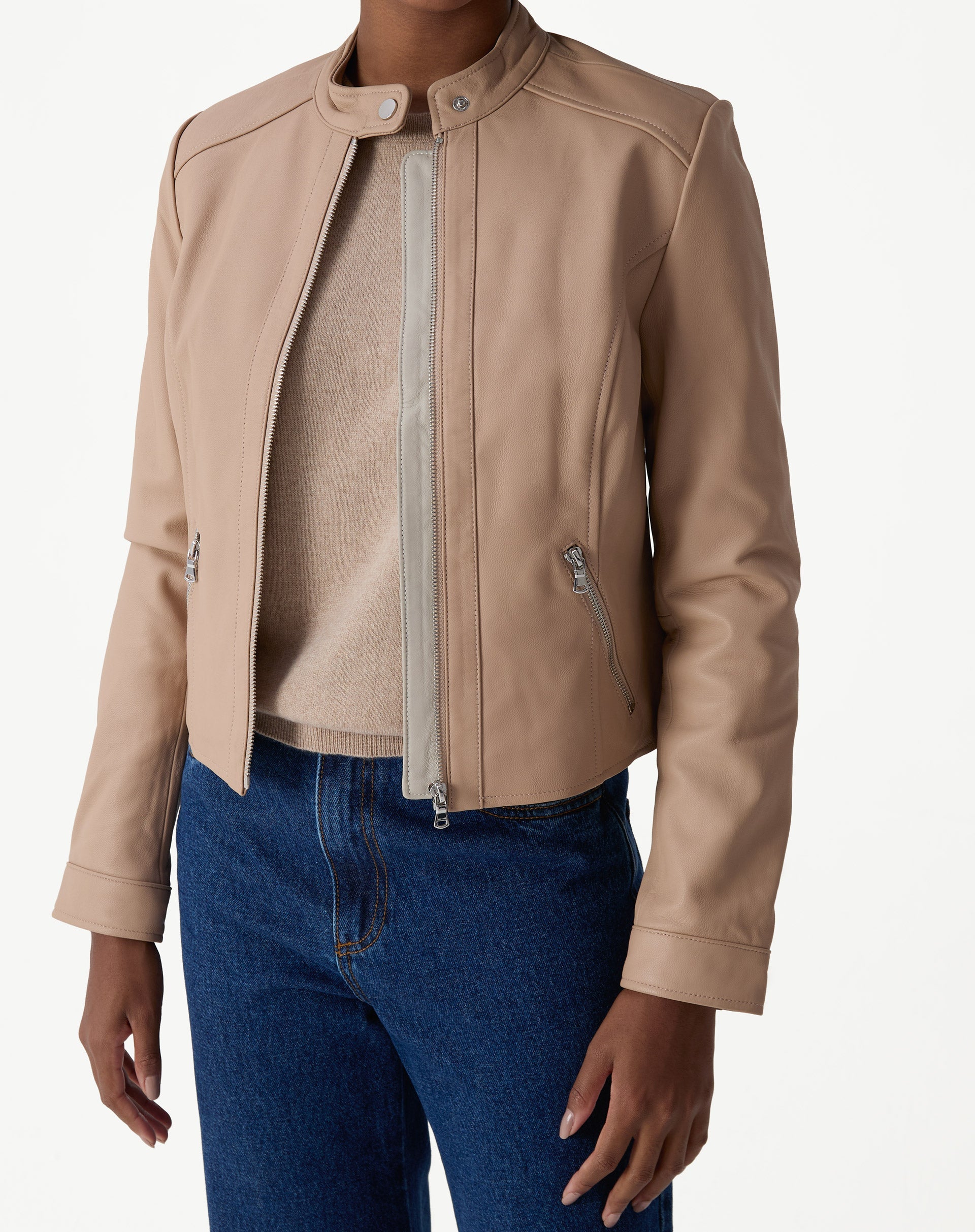 Jaqueta de couro pelica rosa claro vista frontal em modelo, corte curto, zíper metálico central e gola mandarim.