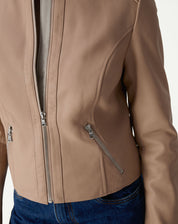 Detalhe frontal da jaqueta mostrando bolso diagonal com zíper metálico e costura que estrutura a peça.