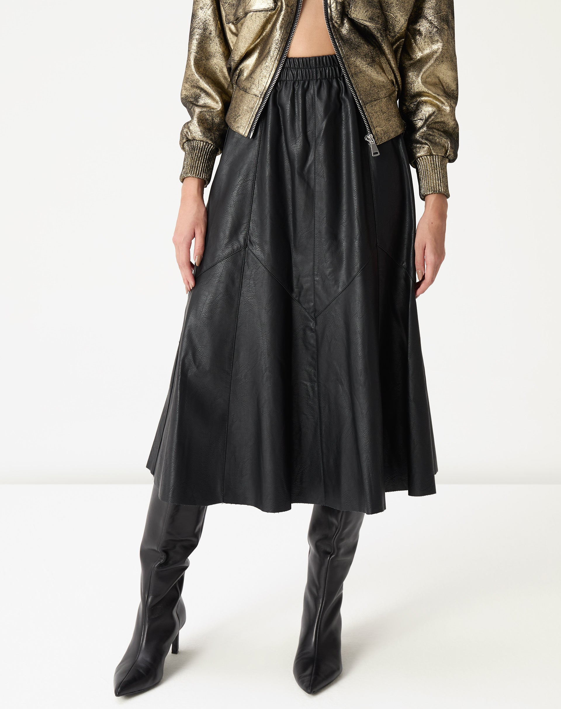 Vista lateral inferior mostrando o caimento midi e os painéis assimétricos da saia statement até a canela