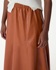 Detalhe dos recortes assimétricos na saia midi Statement em caramelo.