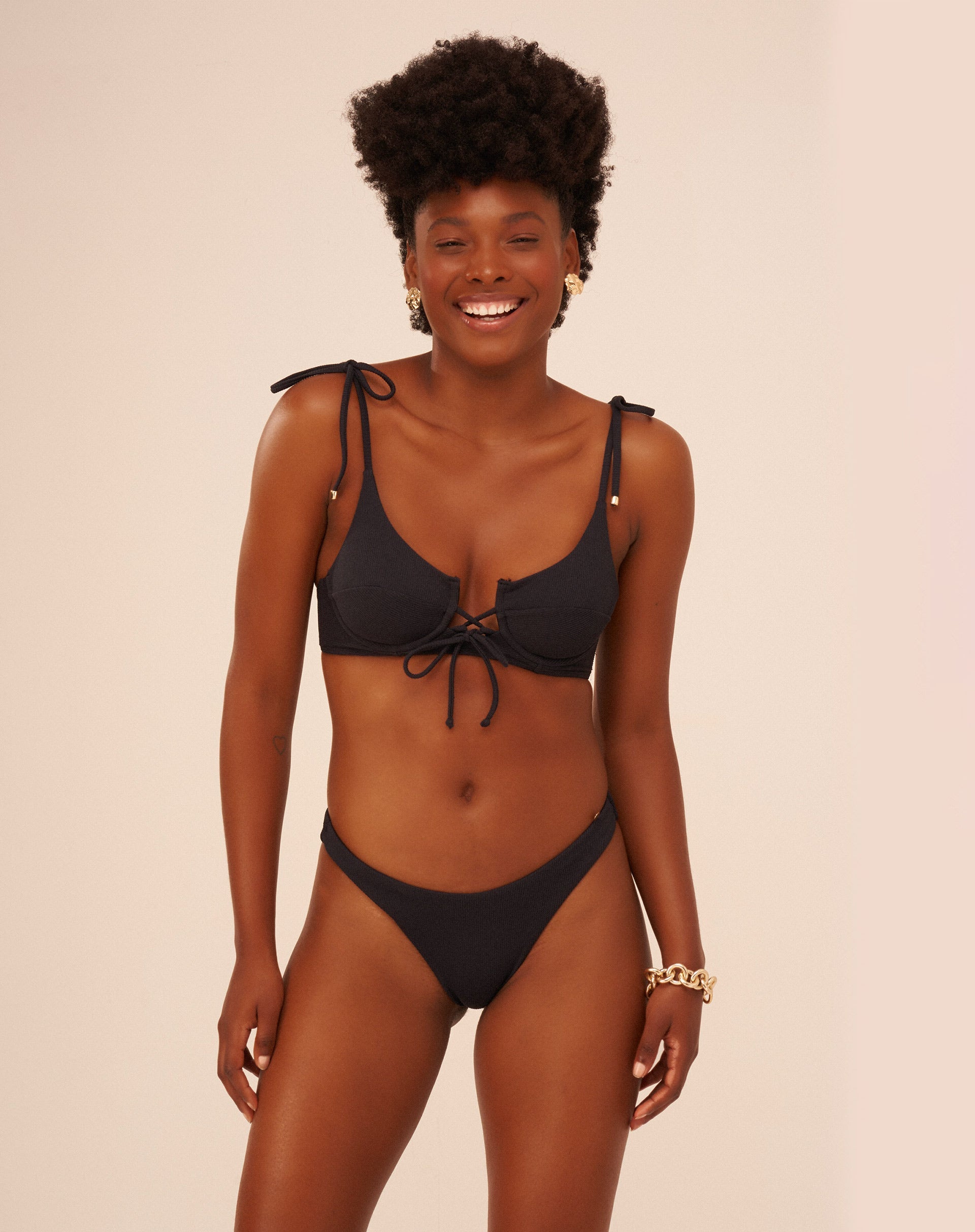 Modelo vestindo um conjunto de biquíni preto com design básico, vista frontal.