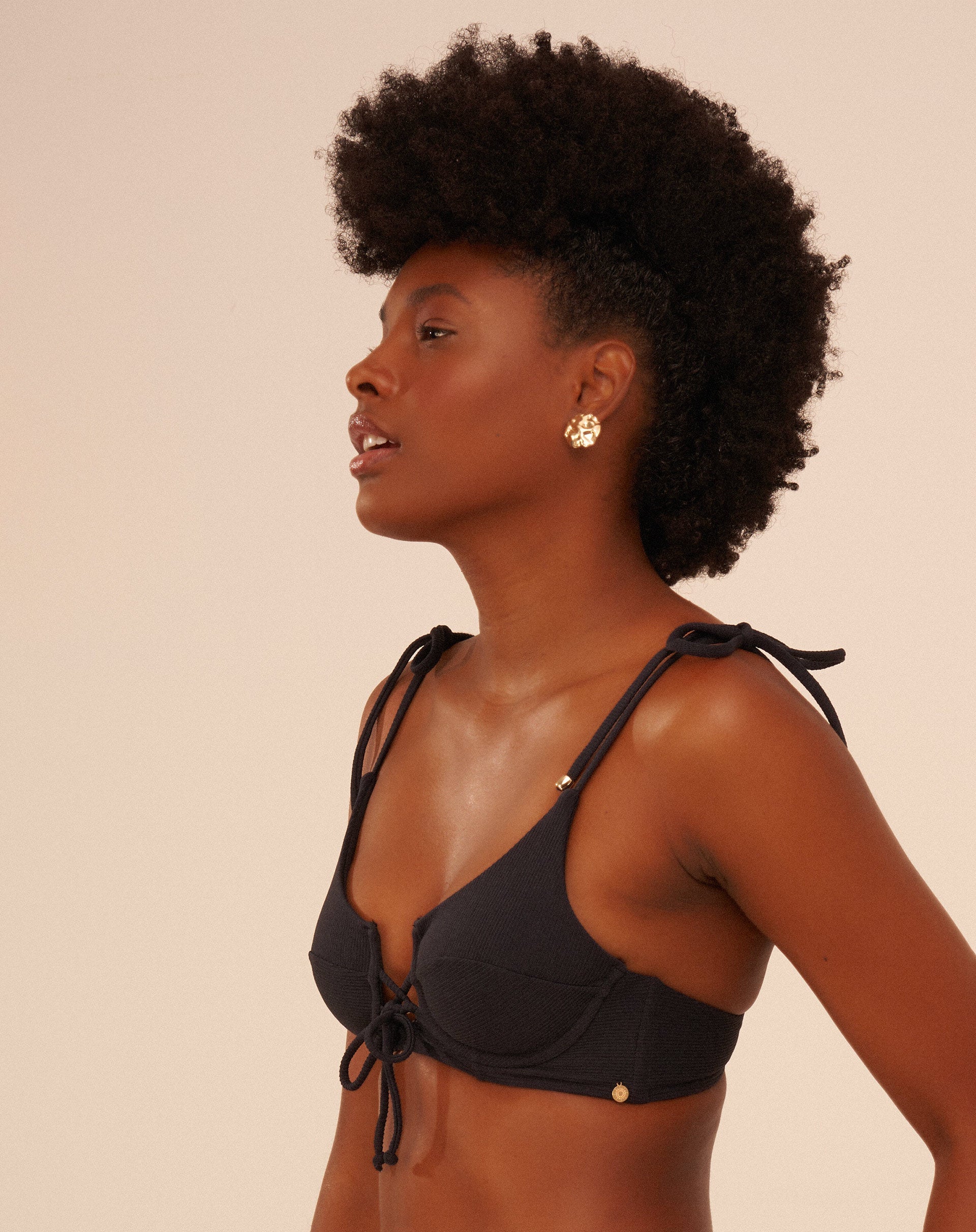 Close-up do detalhe lateral do bottom de biquíni preto.