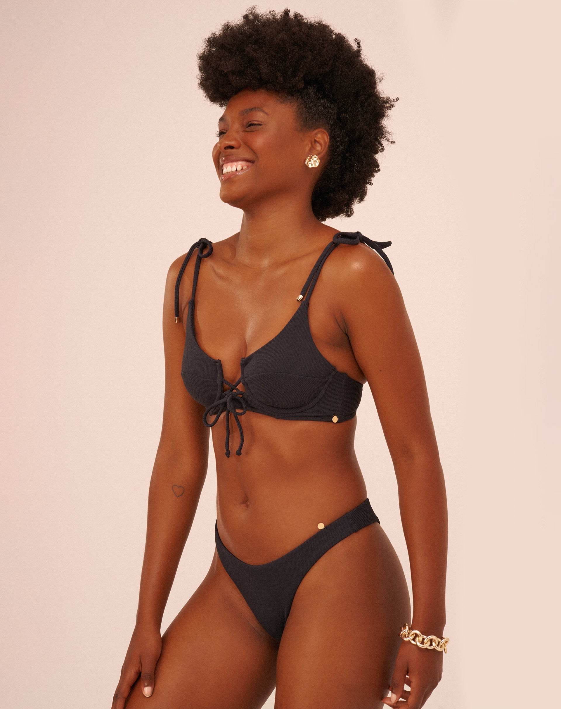 Modelo vestindo um conjunto de biquíni preto com design básico, vista frontal.