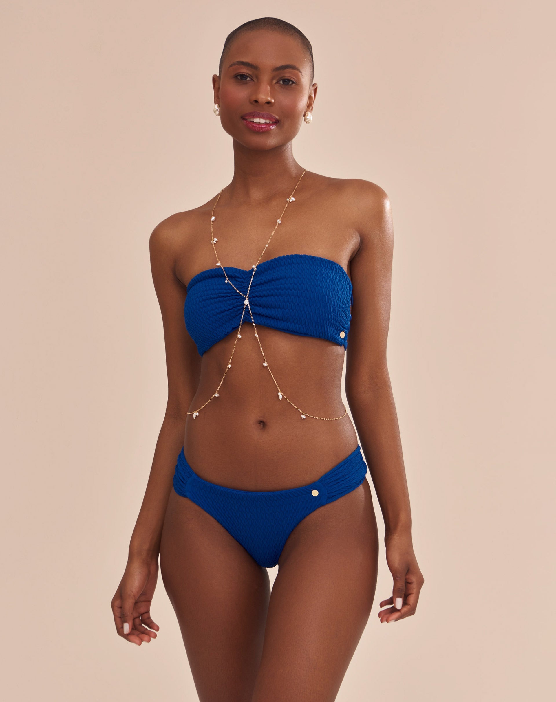 Top bandeau azul vibrante com franzido frontal e tiras entrelaçadas nas costas, visto de frente.