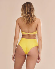 Calcinha de biquíni amarela com detalhes texturizados, vista lateral.