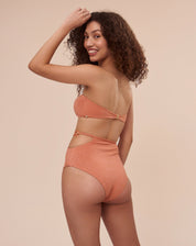Hot pant laranja com argola lateral e tiras finas, vista traseira.