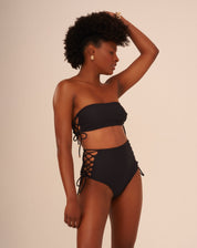 Vista frontal de um top de biquíni preto com entrelaçados laterais, exibindo o design elegante.