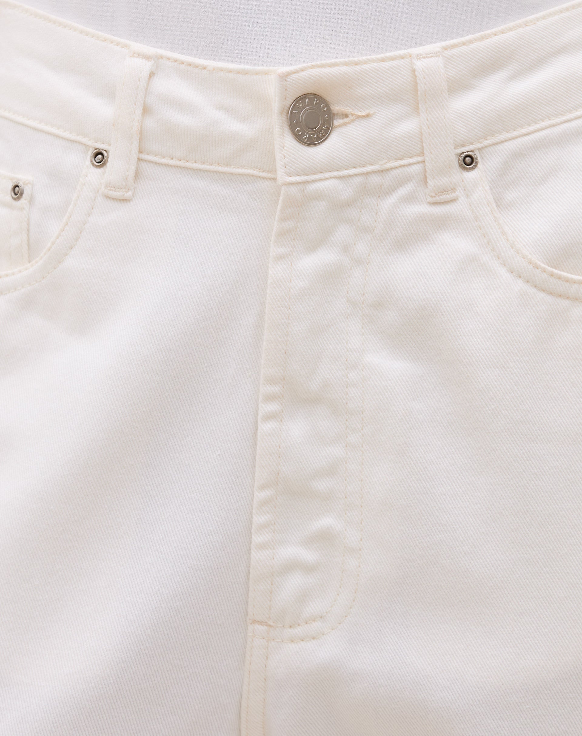 Detalhe do cós alto e fechamento com botão da calça.