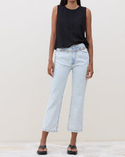 Modelo vestindo calça slim jeans azul claro com blusa preta, vista frontal.