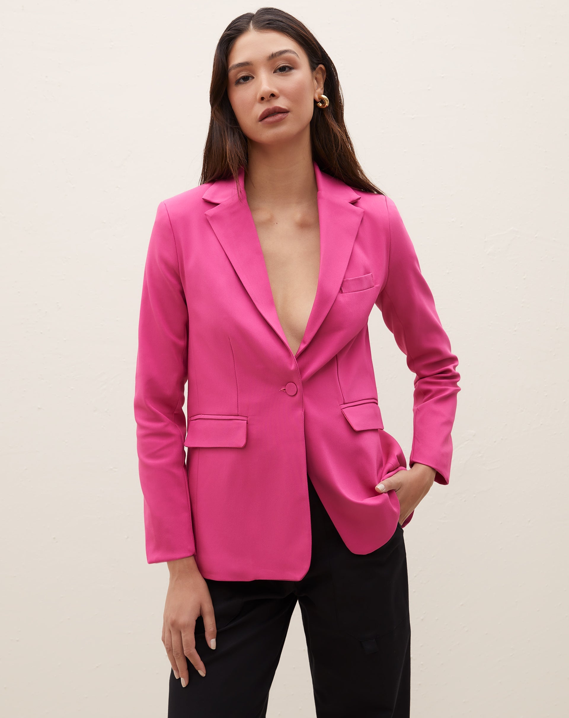 Blazer rosa com lapela e bolsos com aba, visto de costas.