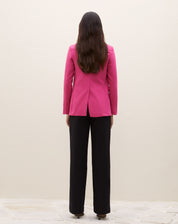 Detalhe do blazer rosa com lapela e bolsos com aba, mostrando o fechamento.