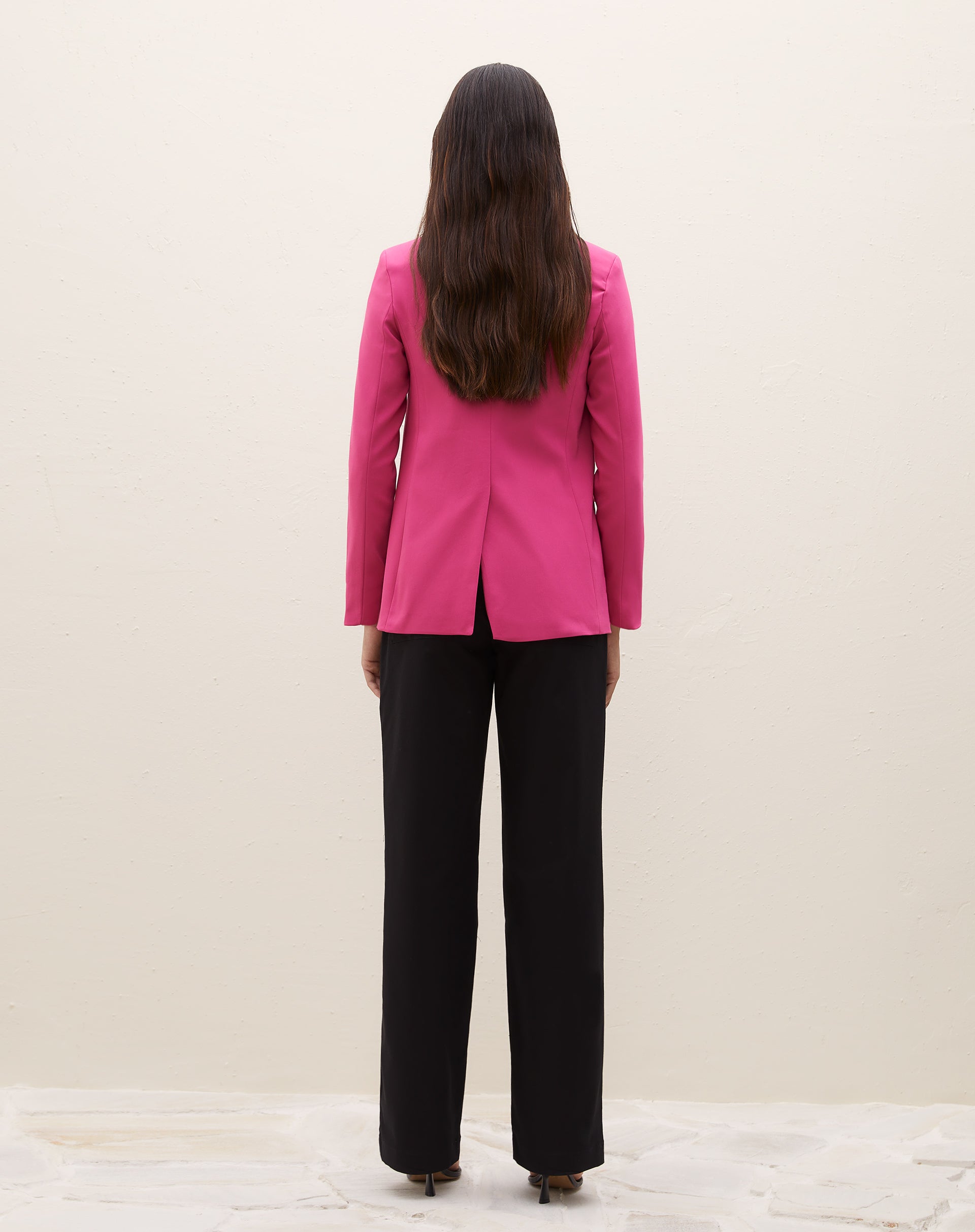 Detalhe do blazer rosa com lapela e bolsos com aba, mostrando o fechamento.