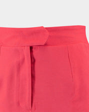 Detalhe do cós e fechamento da saia midi coral em fundo branco.