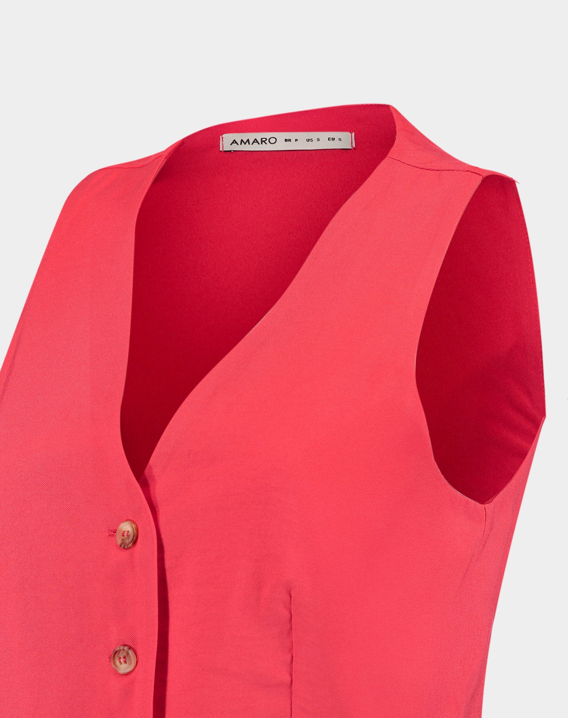 Imagem de um detalhe do colete de alfaiataria vermelho mostrando o decote em V.