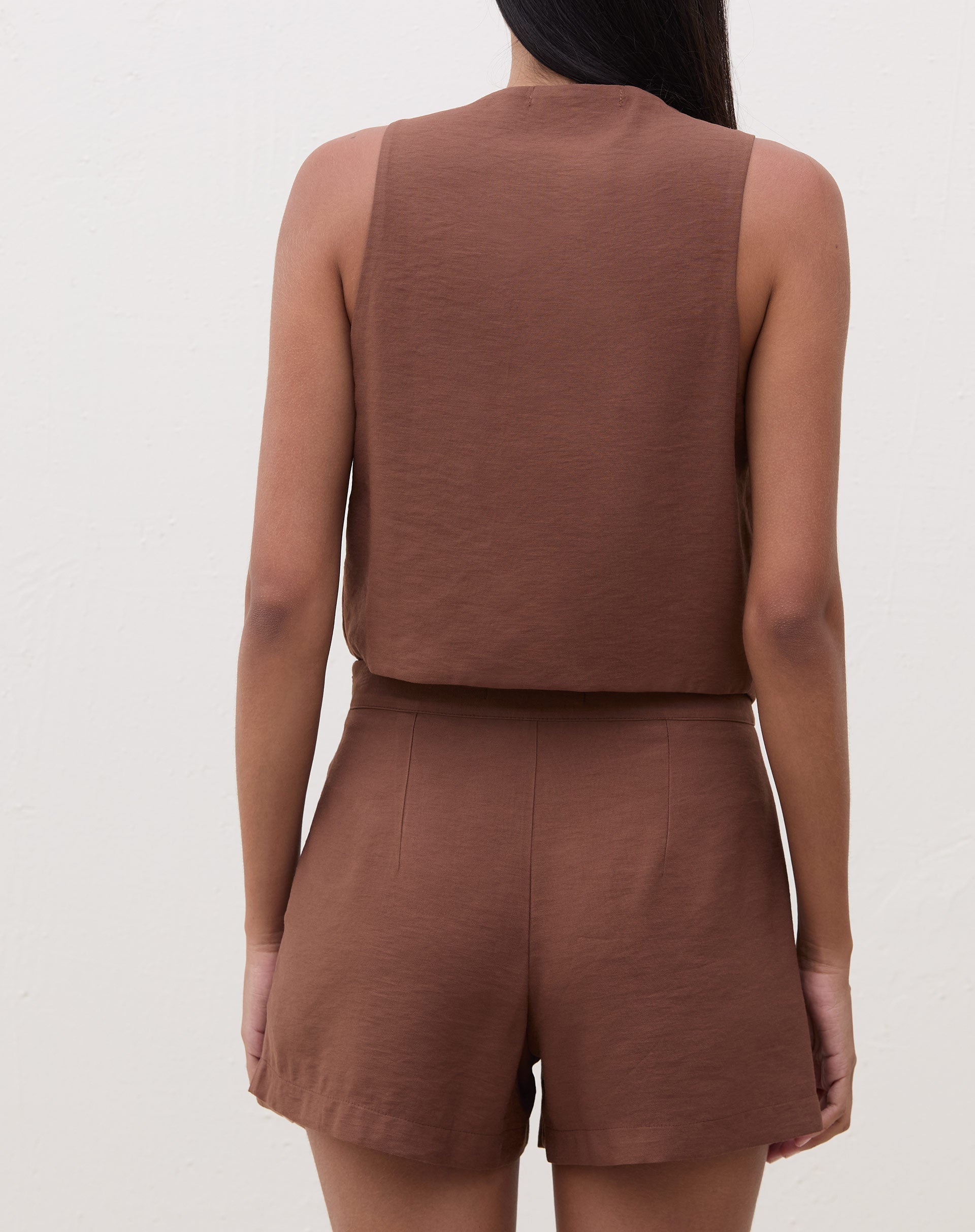 Vista traseira do colete de alfaiataria marrom.