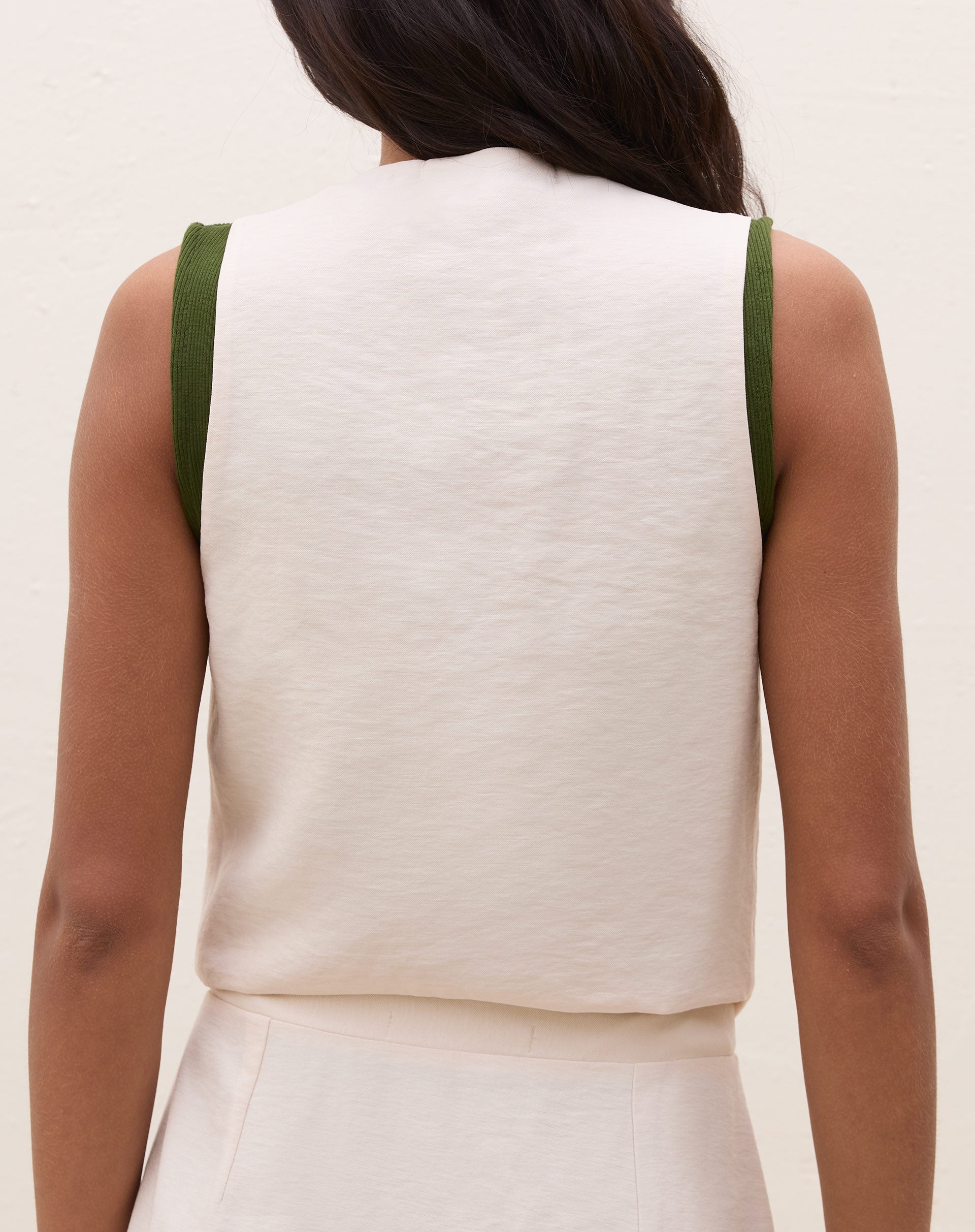 Imagem completa do colete de alfaiataria bege combinado com uma saia.