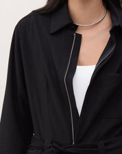 Vista traseira do macacão preto mostrando o caimento reto.