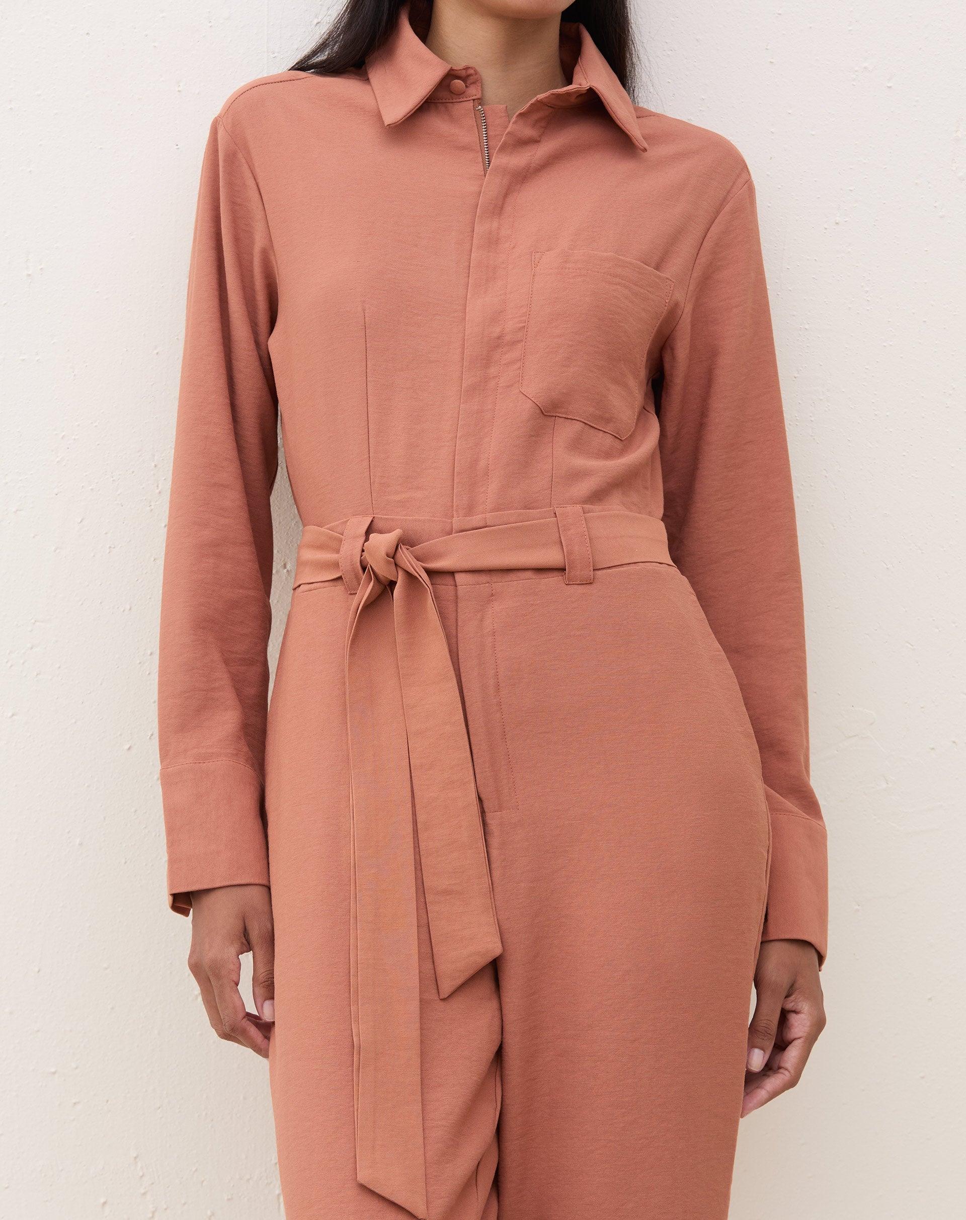 Detalhe do macacão caramelo mostrando a amarração na cintura.