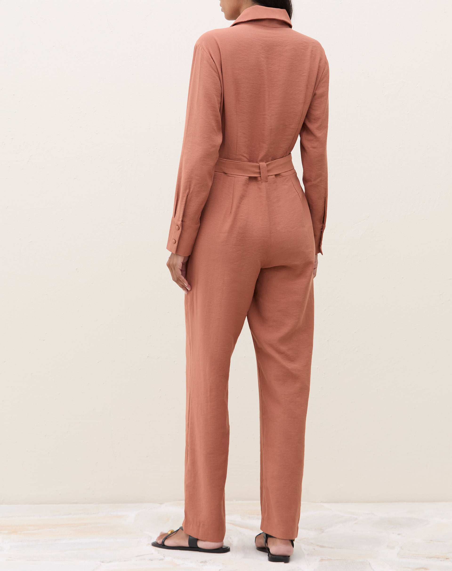 Vista traseira do macacão caramelo com mangas longas.