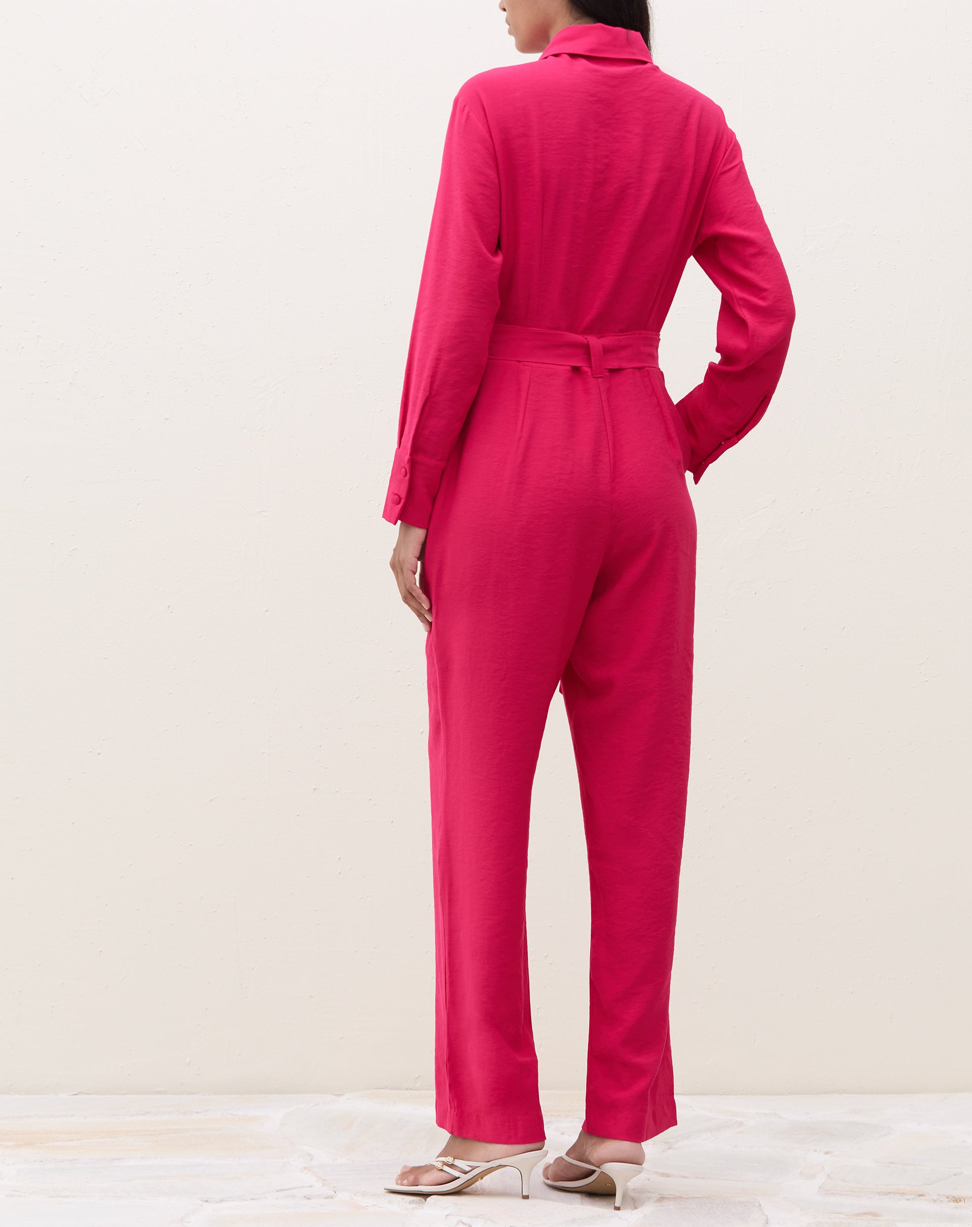 Vista traseira do macacão cereja com amarração na cintura.