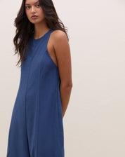 Vista lateral do macacão azul mostrando o ajuste na cintura.