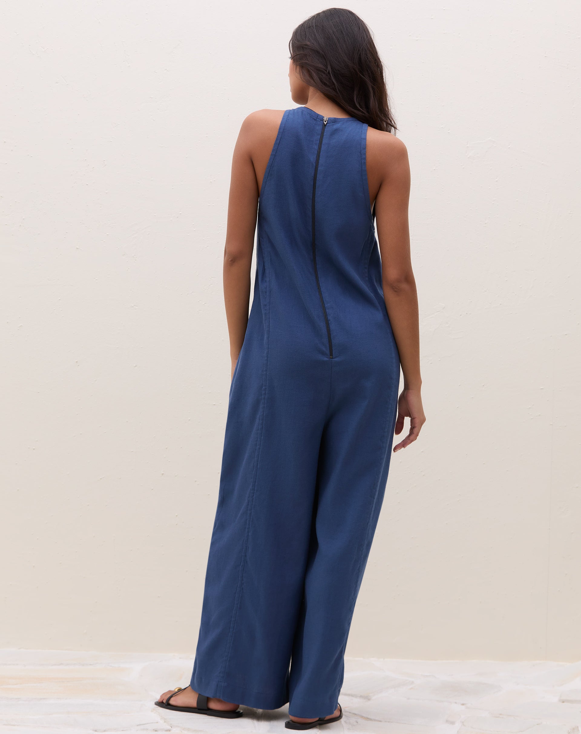 Vista traseira do macacão azul com fechamento em zíper.