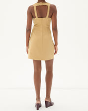 Vestido curto frente única em alfaiataria na cor areia, visto de costas, destacando o detalhe do fecho.