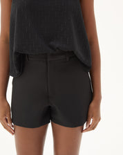 Close-up do shorts curto reto de alfaiataria preto mostrando detalhes do cós e acabamento.