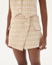 Vista frontal do shorts de alfaiataria com estampa xadrez, destacando o cós e fechamento.