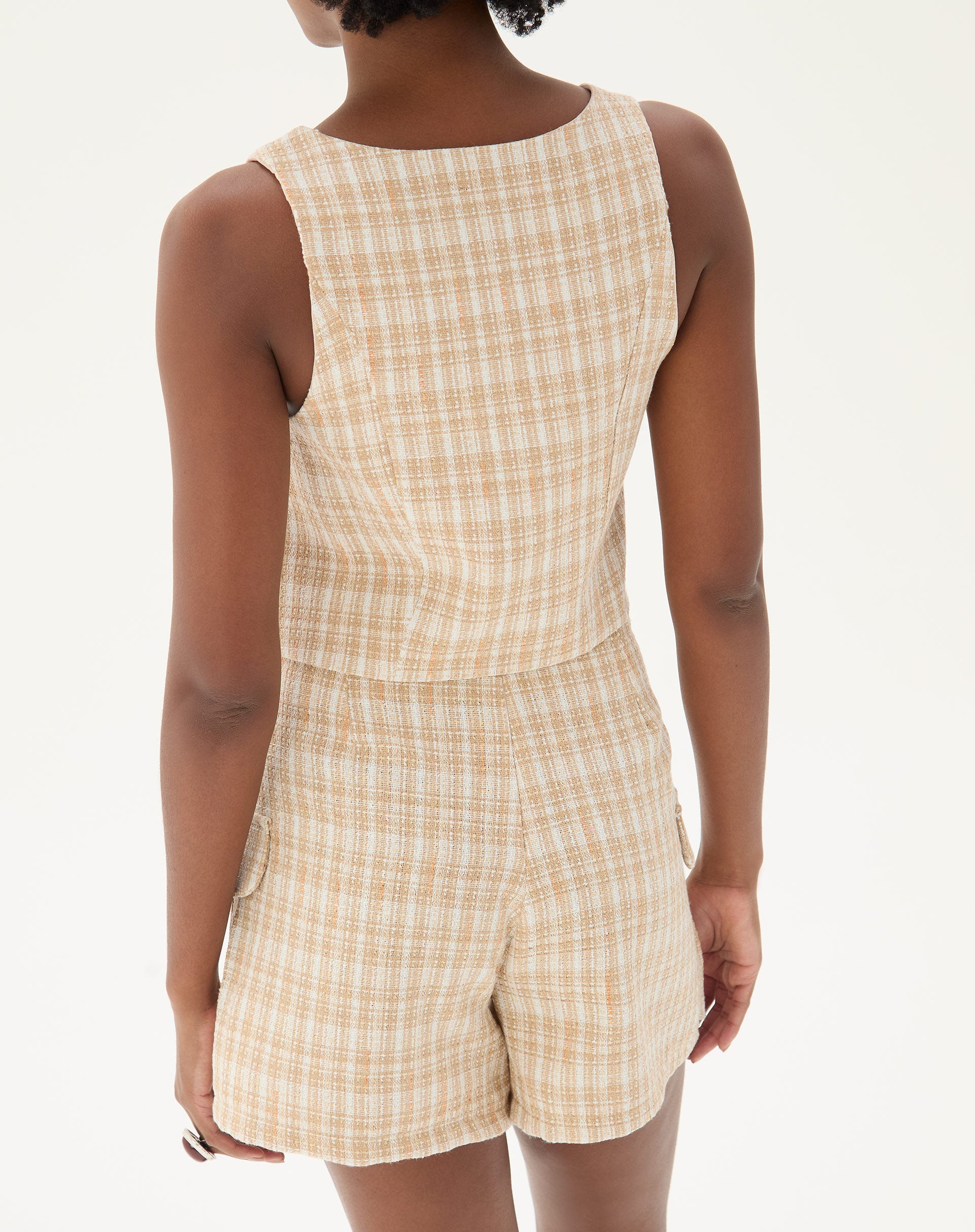 Vista traseira do shorts de alfaiataria com estampa xadrez, destacando o ajuste e caimento.