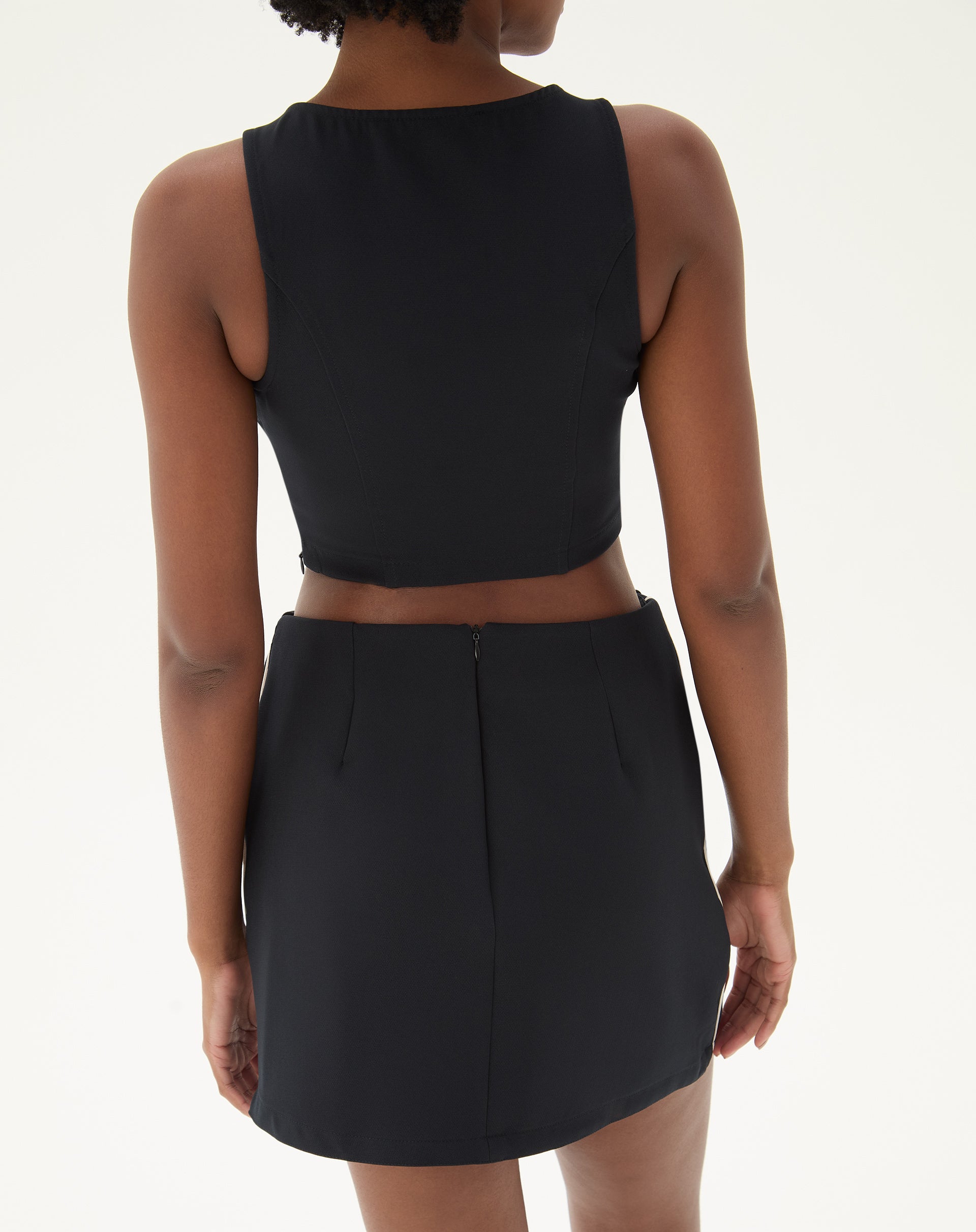 Vista traseira da saia preta, mostrando o fechamento com zíper e o corte reto.