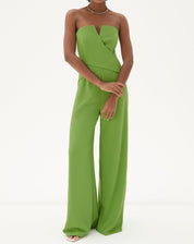 Imagem de um macacão sem alças de alfaiataria em verde, visto de frente, destacando o design minimalista e elegante.