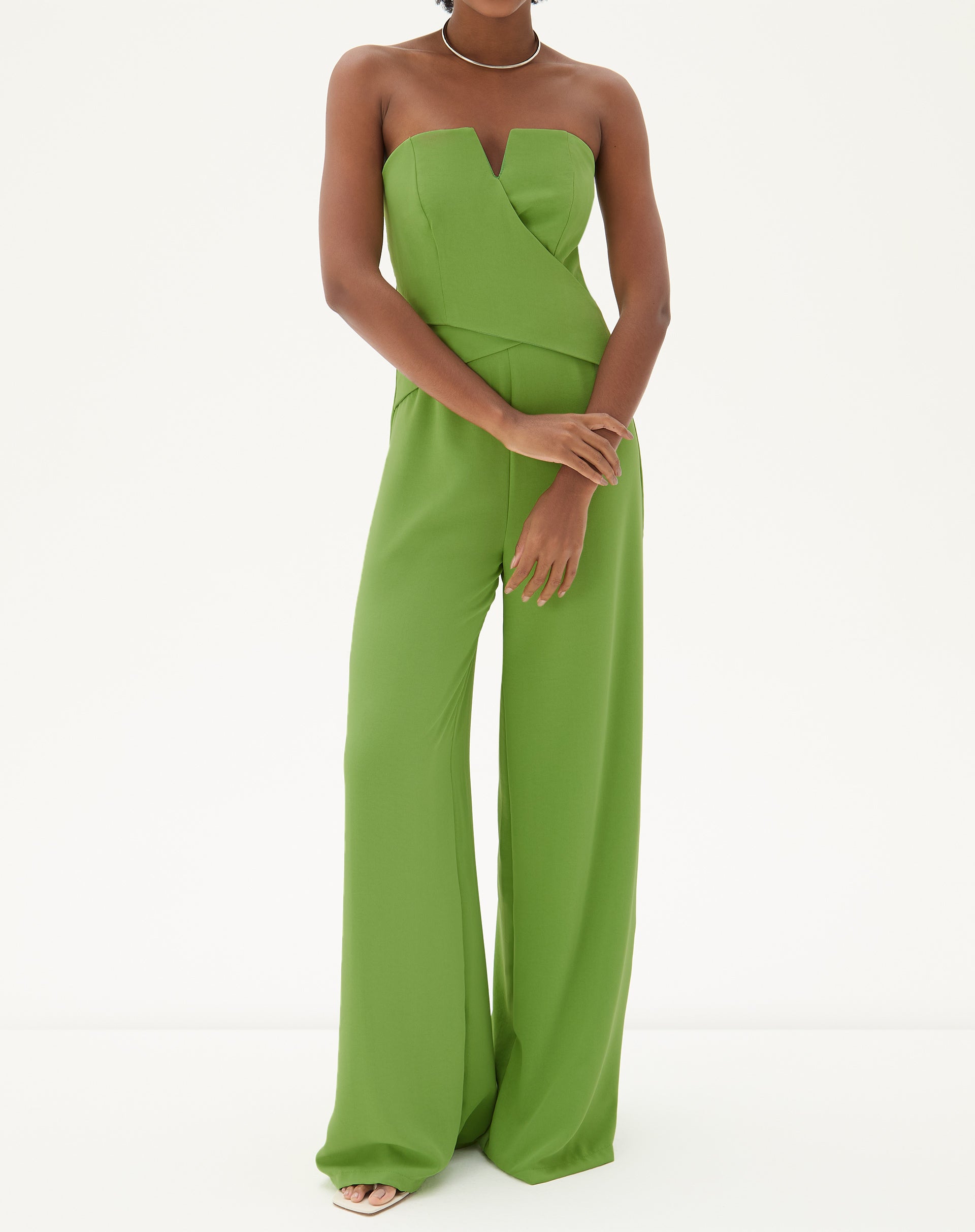 Imagem de um macacão sem alças de alfaiataria em verde, visto de frente, destacando o design minimalista e elegante.