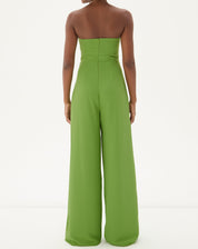 Close-up do decote reto do macacão sem alças de alfaiataria em verde, evidenciando o acabamento impecável.