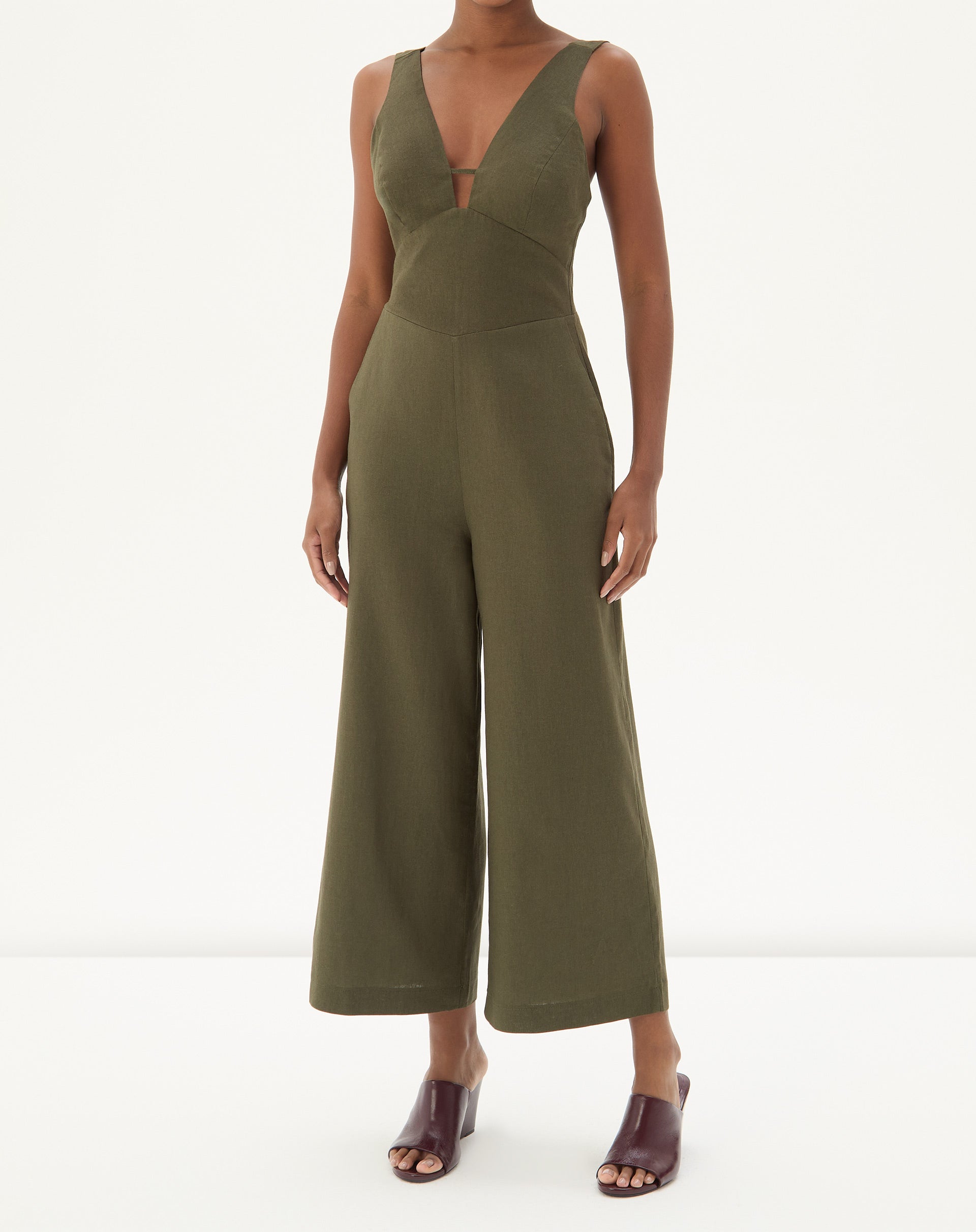 Vista frontal do macacão verde com design de alfaiataria e pernas largas.