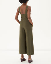 Vista traseira do macacão verde destacando o fechamento e bolsos laterais.