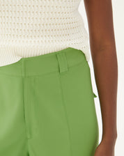 Detalhe do cós e bolsos frontais da calça reta verde.