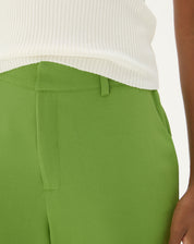 Vista traseira da calça verde mostrando o ajuste e design.