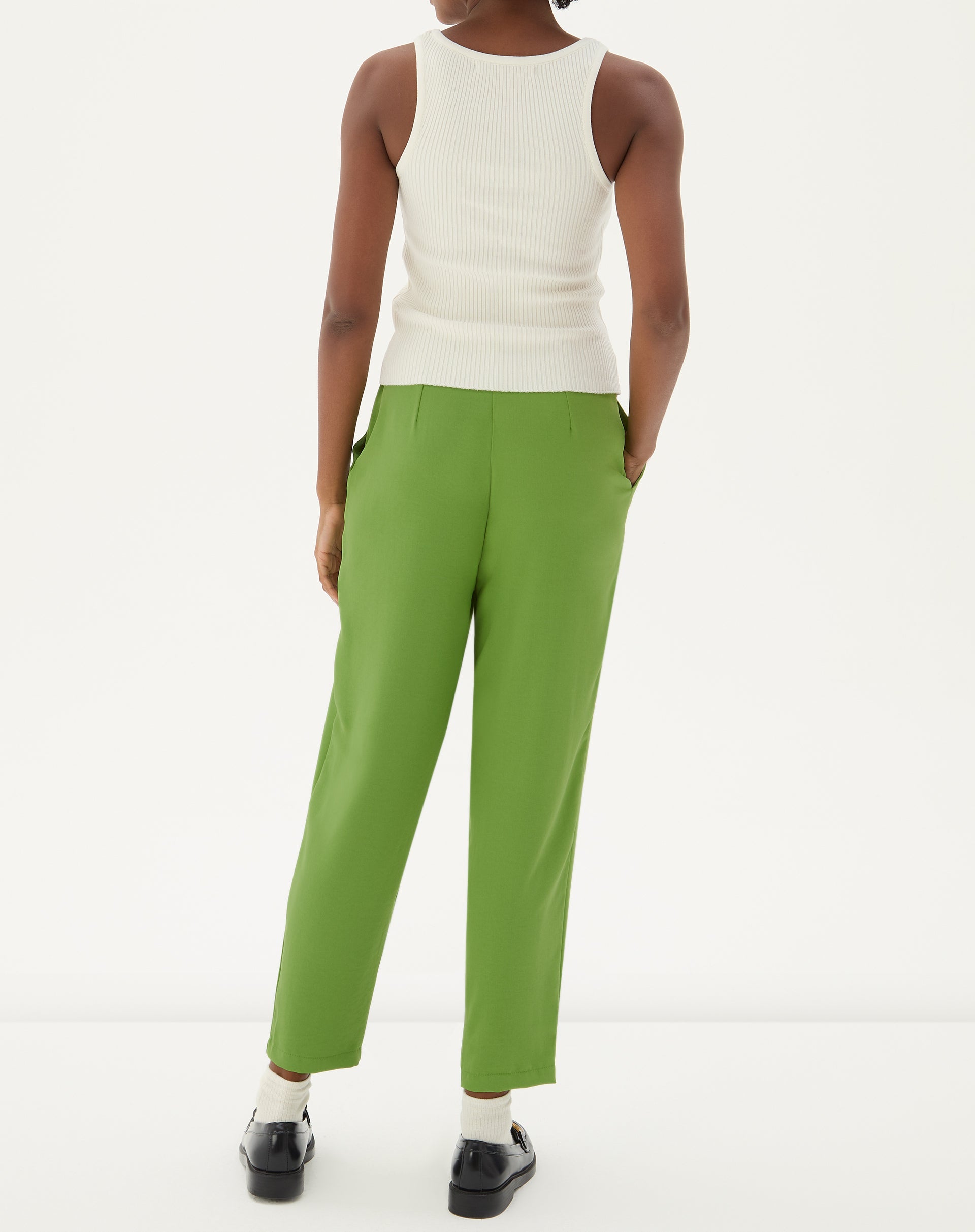 Detalhe do tecido e acabamento da calça verde.