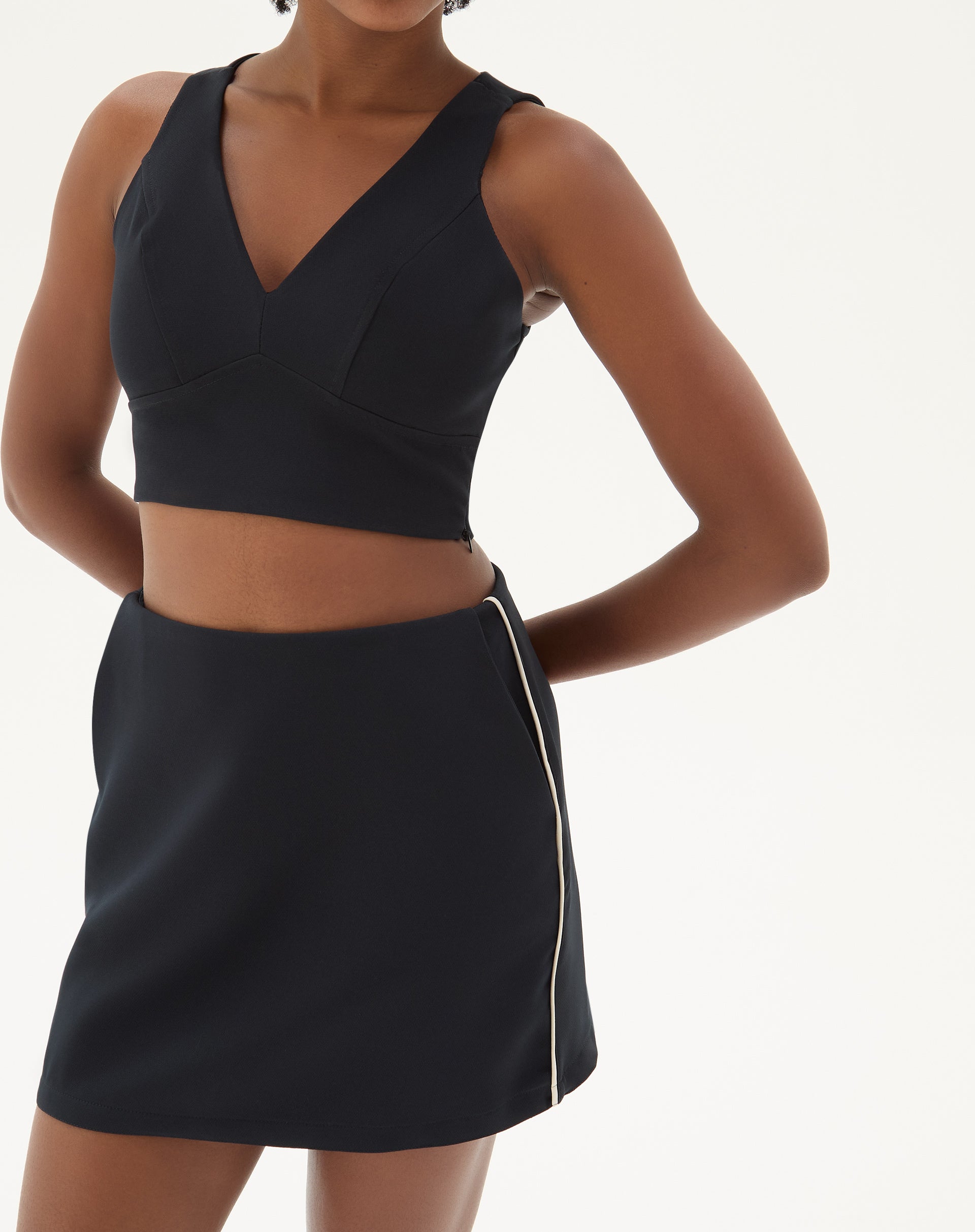 Blusa preta decote V vista de frente, destacando o design minimalista e o tecido fluido.