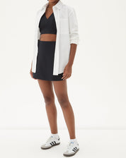 Modelo vestindo a blusa preta com saia combinando, criando um look sofisticado.