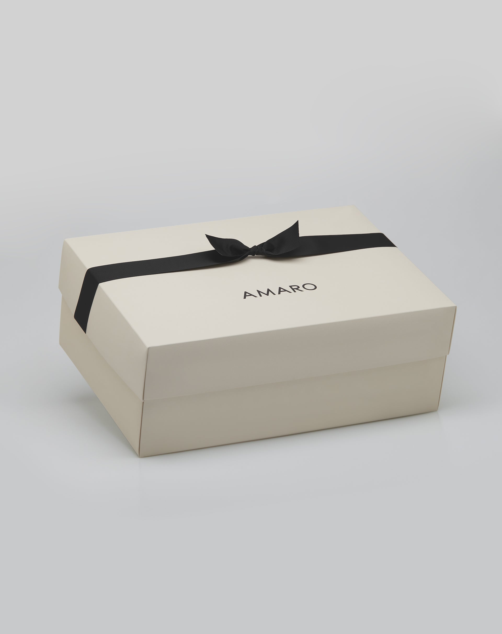 Embalagem de presente AMARO tamanho G na cor off-white com laço preto.