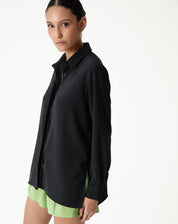 Camisa preta de manga longa com barra reta, vista lateral mostrando o caimento.