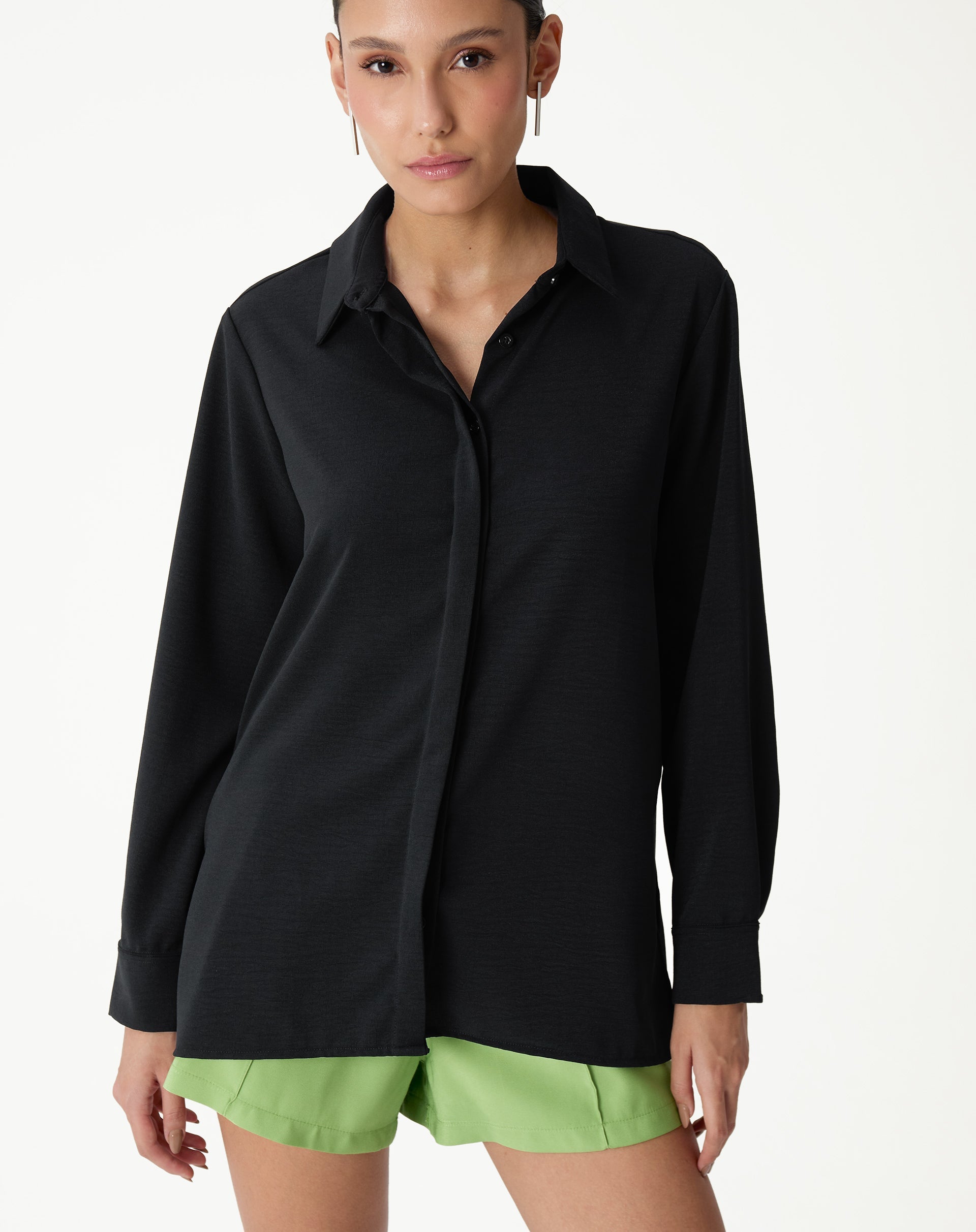 Camisa preta de manga longa com barra reta, vista frontal destacando o colarinho.