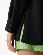 Detalhe do punho da camisa preta com botões.