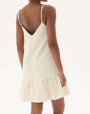 Vista traseira do vestido curto bege com alças finas e barra em babado.