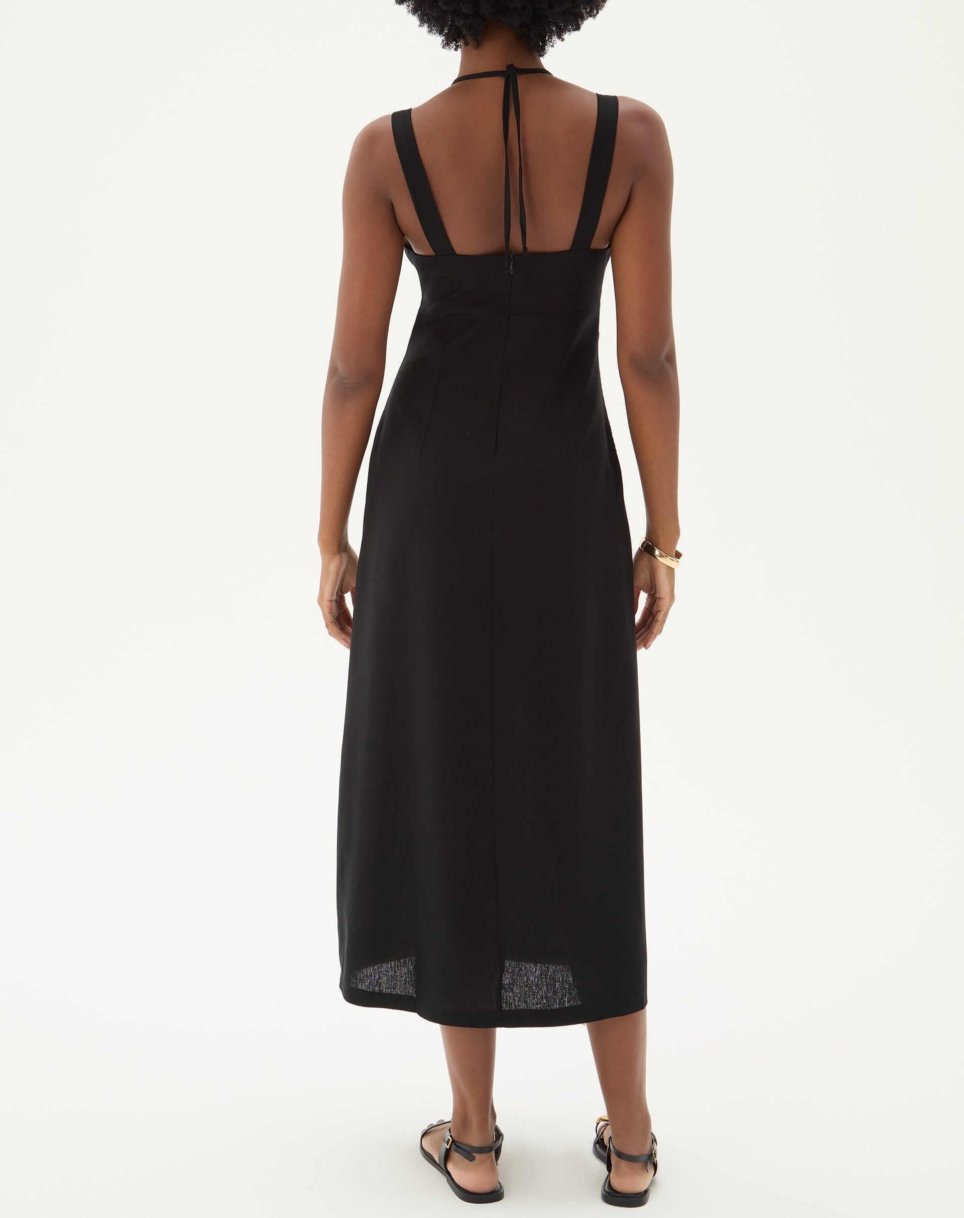 Vista traseira do vestido preto com alças finas e comprimento midi.