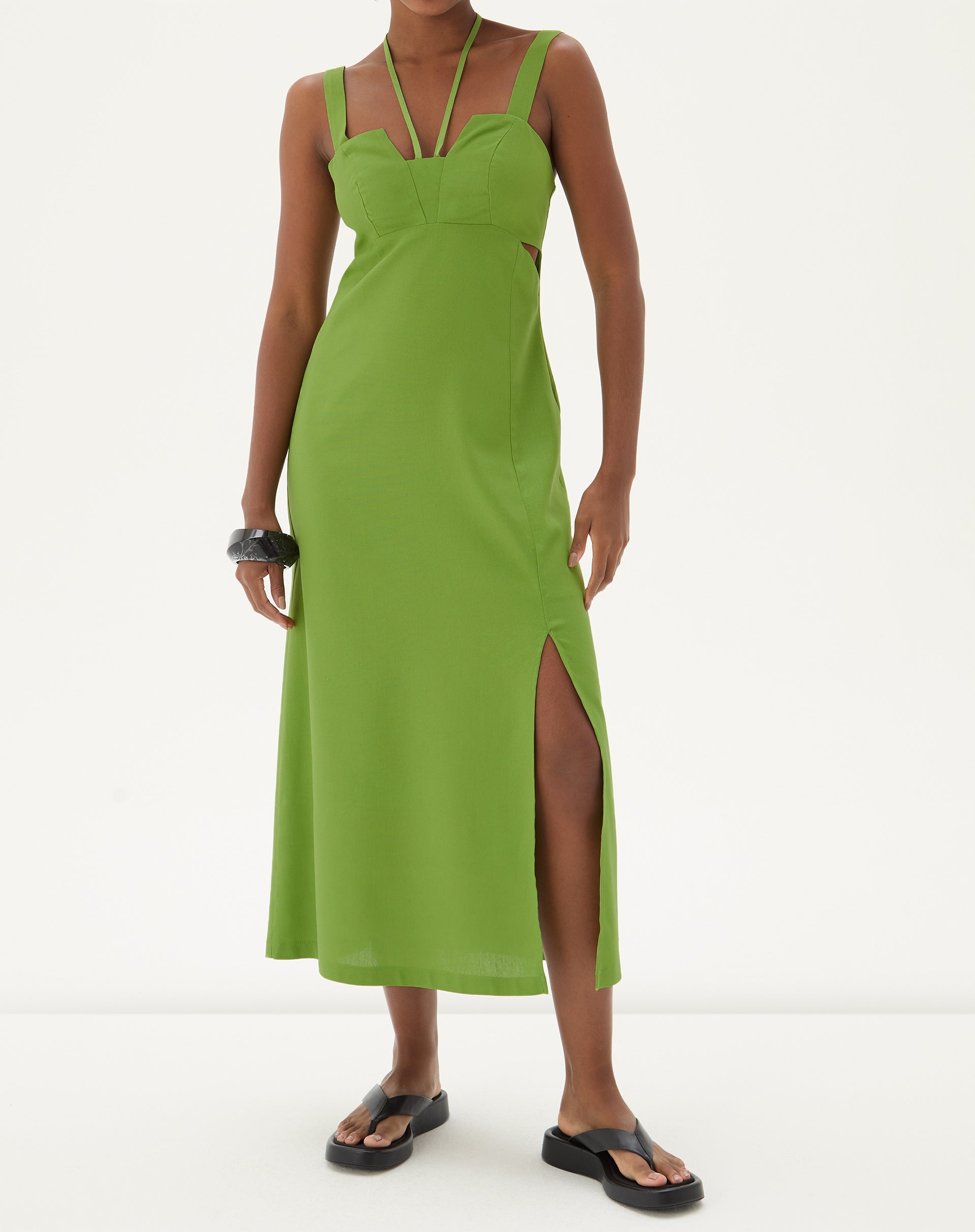 Vestido longo verde com fenda lateral, alças finas e decote reto, exibido em modelo de frente.