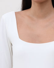 Detalhe do decote quadrado do body em off-white.