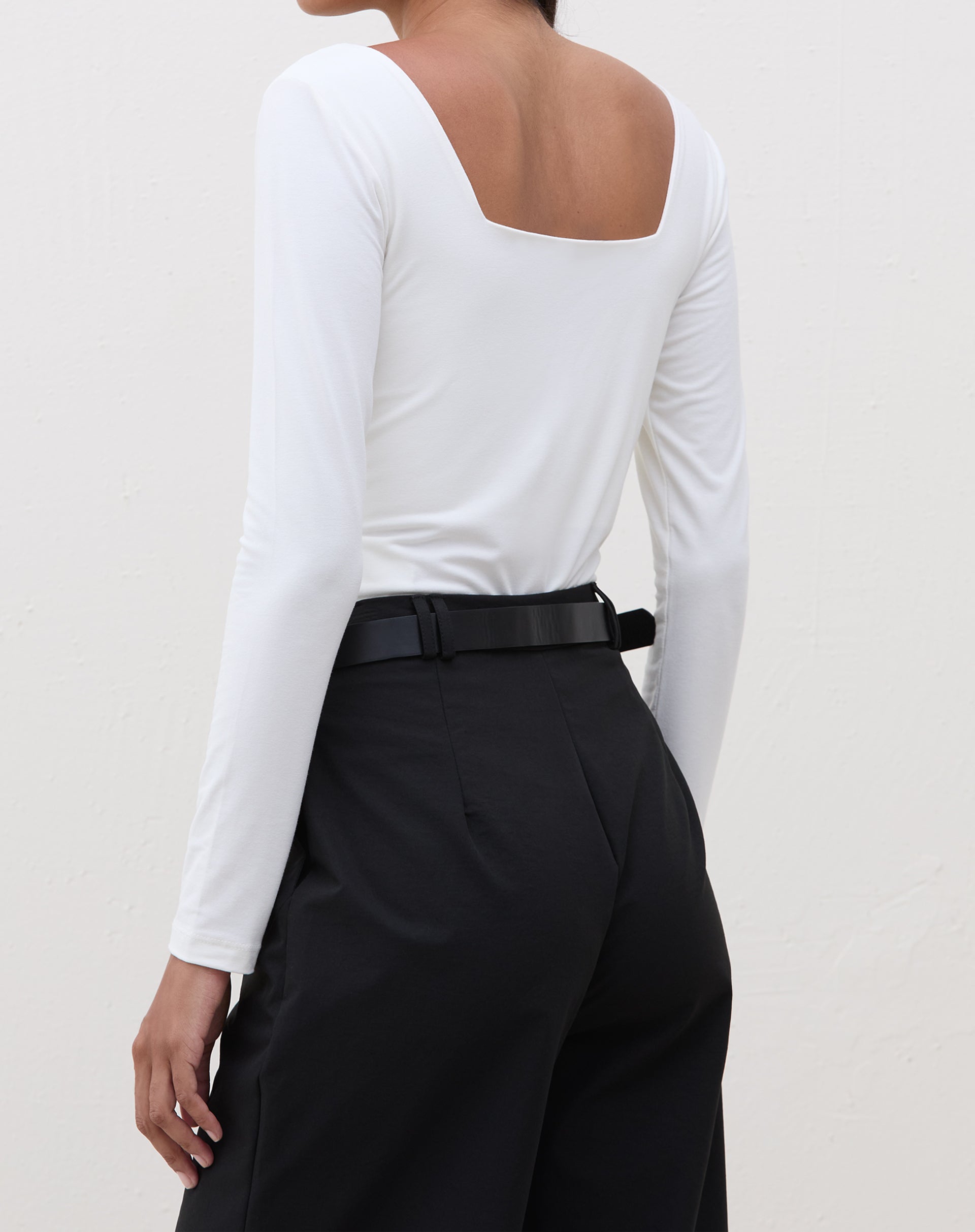 Vista traseira do body manga longa em off-white.